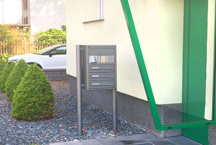 Am Hauseingang aufgestellte freistehende Briefkastenanlagen