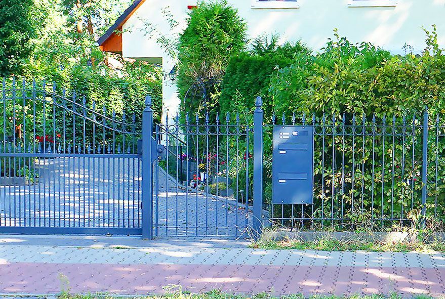 Am Zaunfeld montierte Durchwurfbriefkastenanlagen mit rückseitiger Postentnahme und viel Fassungsvermögen