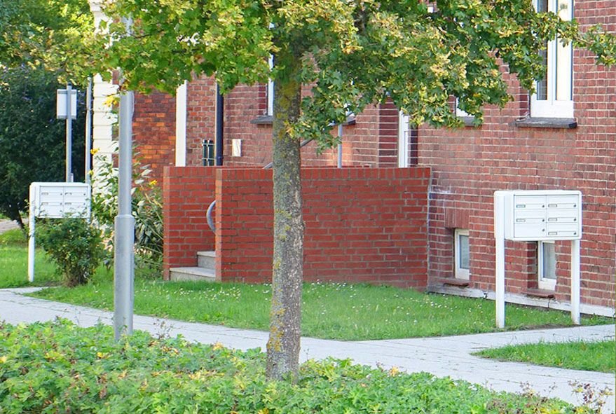 Direkt am Gehweg positionierte Briefkastenanlagen in gleicher Bauform und identischer Farbgebung