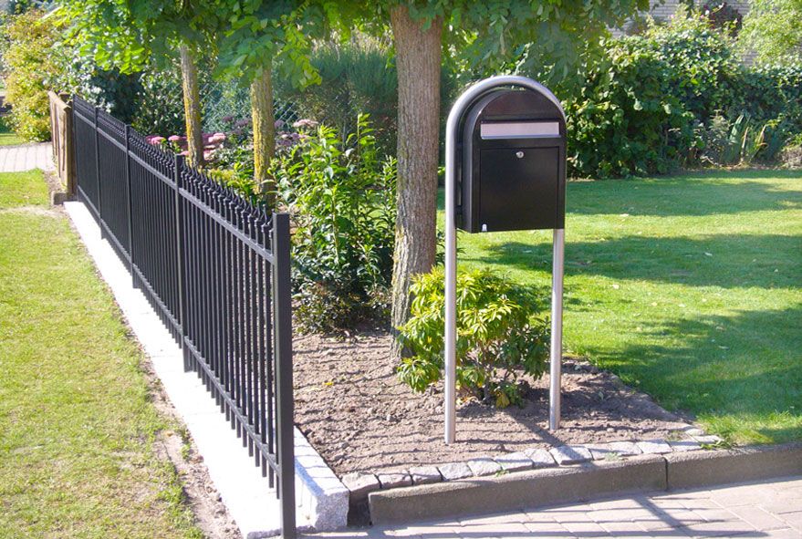 Direkt am Zaun platzierter freistehender Briefkasten mit dazu passendem Edelstahlständer