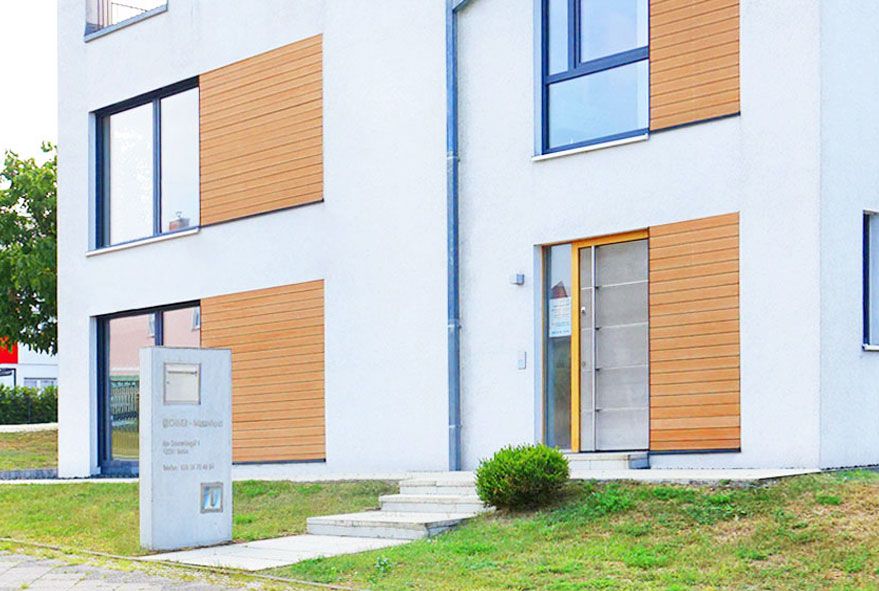 Eine Betonstele stellt eine solide Grundlage für funktionelle Edelstahlbriefkästen mit beleuchteter Hausnummer dar