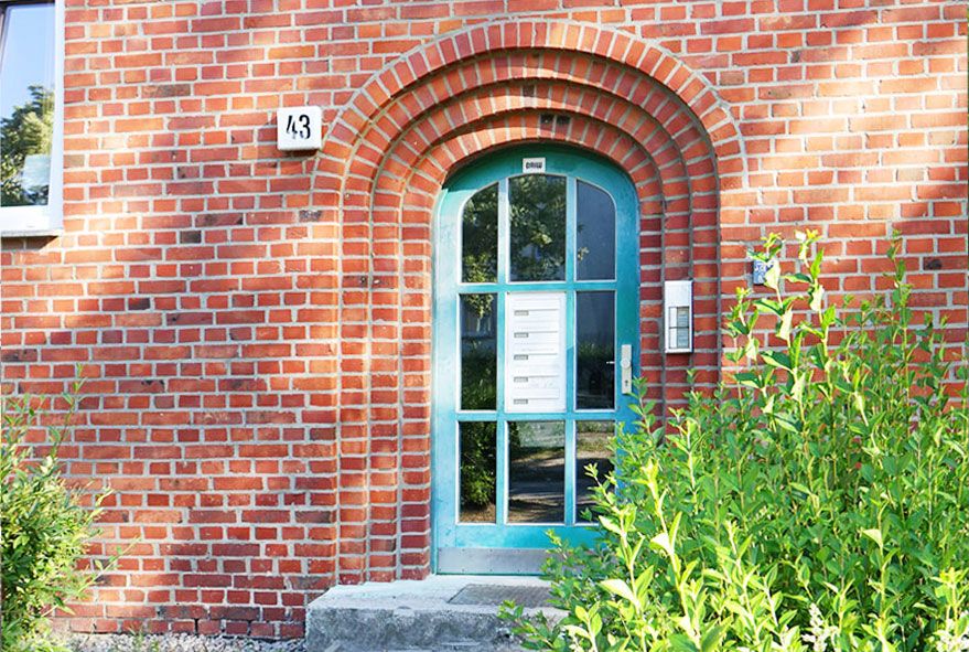 Eine mittig im Türfeld eingelassene Durchwurfbriefkastenanlage spart Platz im Hauseingangsbereich