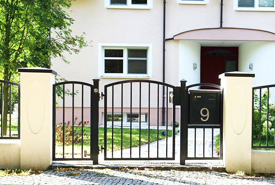 Im festen Torelement stabil verankerte Briefkastenanlage mit großer gelaserter Hausnummer