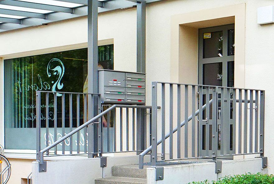 In den Treppenaufgang eingepasste Briefkastenanlage für die Geländermontage mit Wetterschutz