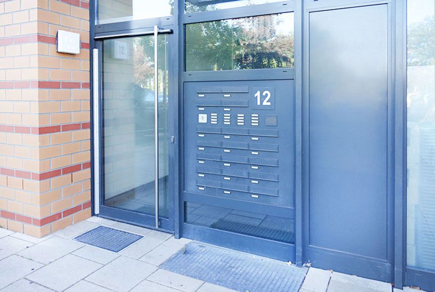 In einer Hauseingangstür oder daneben eingebaute solide Briefkastenanlage