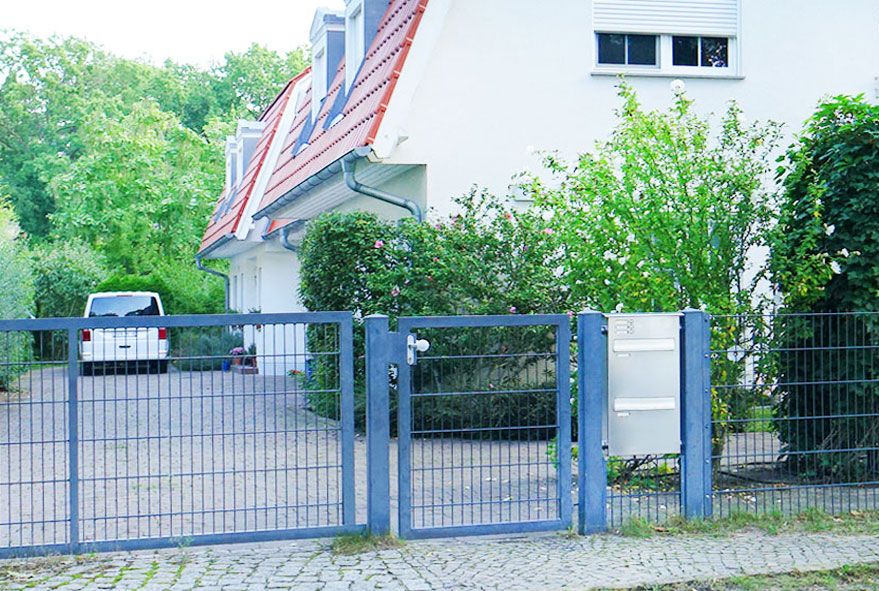 Mit hochwertigem Klingelsystem und Namensschild ausgestattete Zaunbriefkastenanlage mit Entnahme von hinten