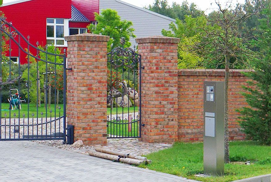 Namens- oder Unternehmenslogo kombiniert mit Hausnummer an einer beleuchteten Briefkastenanlage